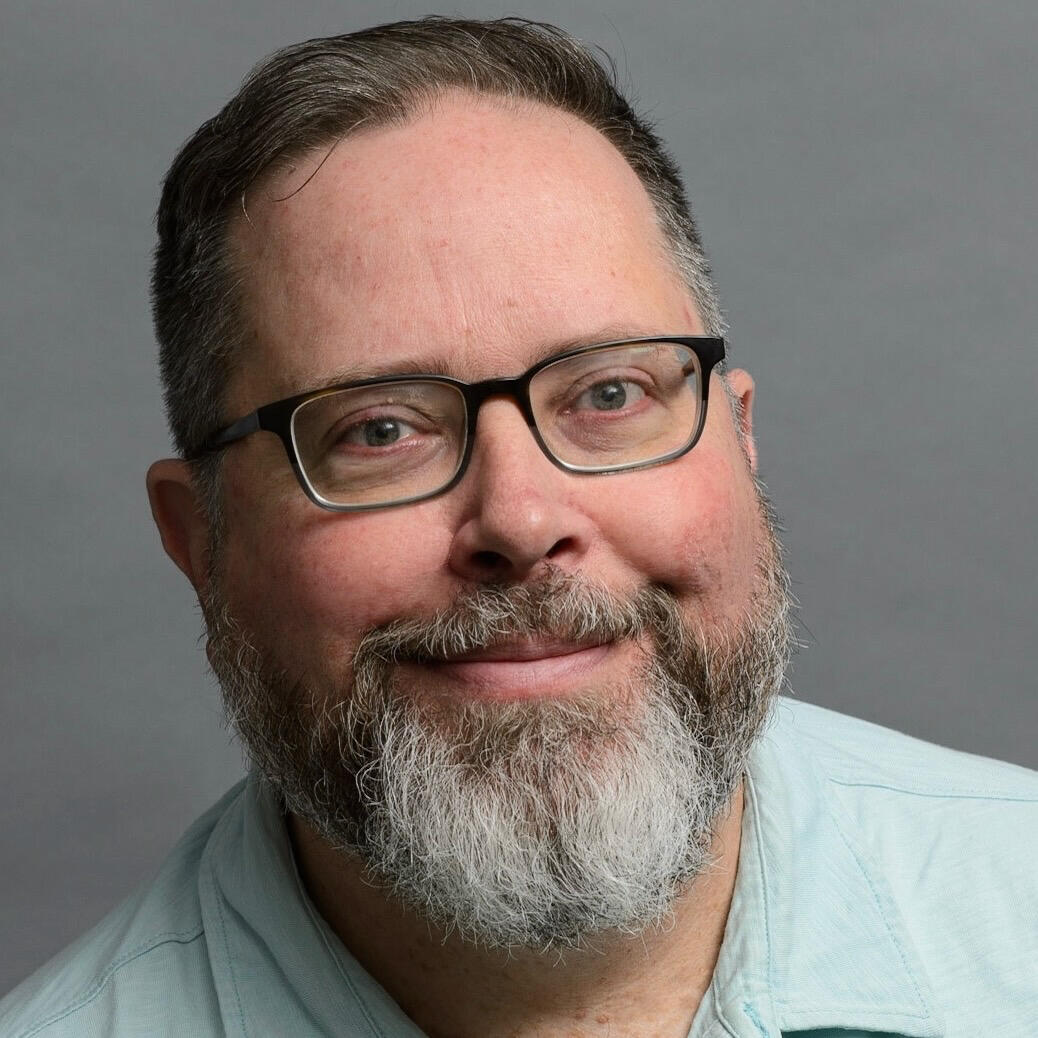 Chad Moore, smiling, with glasses and a gray beard